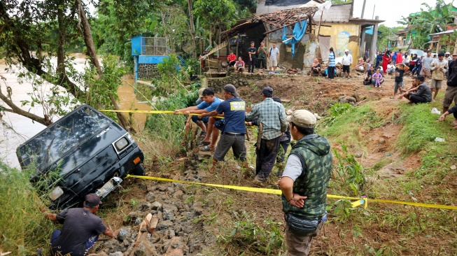 Sejumlah warga berusaha menarik mobil yang terbawa banjir bandang di Kampung Parungseah, Desa Curug Luhur, Sagaranten, Kabupaten Sukabumi, Jawa Barat, Kamis (5/12/2024). [ANTARA FOTO/Iman/Arf/YU]