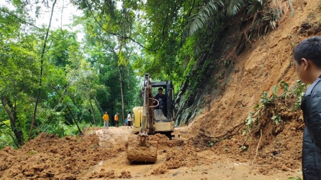 Petugas Dinas Binamarga Propinsi Jawa Barat, membuka kembali jalur utama Cianjur selatan yang putus akibat longsor di Kecamatan Pagelaran, agar dapat dilalui kendaraan, Jumat (6/12/2024).(ANTARA/Ahmad Fikri)