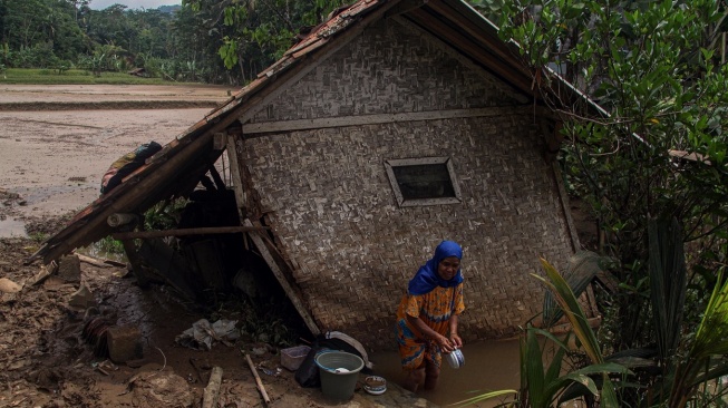 Warga mencuci perkakas dapur pascabanjir bandang di Sagaranten, Kabupaten Sukabumi, Jawa Barat, Minggu (8/12/2024). Warga mulai membersihkan sisa lumpur dan barang rumah tangga pascabanjir bandang setinggi 2,5 meter yang menerjang wilayah tersebut. ANTARA FOTO/Yulius Satria Wijaya/rwa. 